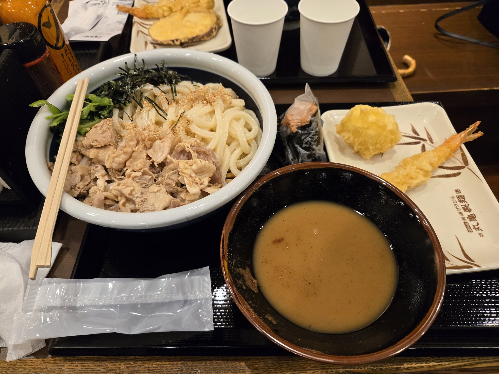 丸亀製麺 濃厚魚介豚つけ汁うどんの実物（冷たいうどんと豚しゃぶ、白濁したつけ汁、天ぷら）